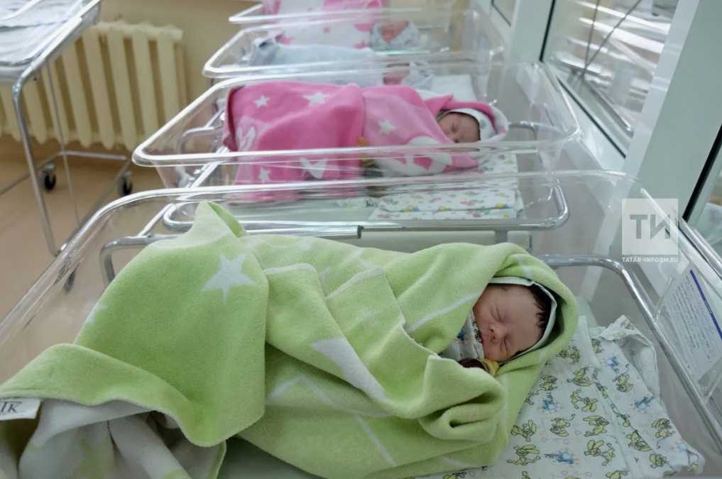 Новорожденные лежат в кроватках